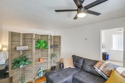 a living room with a couch and a ceiling fan at 2 Mi to Ocean! Executive-Style Oasis in Long Beach in Long Beach