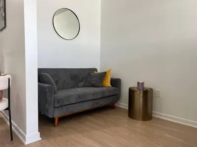 a living room with a gray couch and a mirror at Fortuna-Seaside Retreat in Santa Monica, steps to the beach, free parking in Los Angeles
