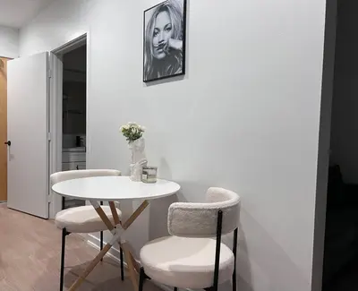 a table with two chairs and a table with a vase at Fortuna-Seaside Retreat in Santa Monica, steps to the beach, free parking in Los Angeles
