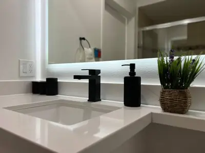 a white bathroom with a sink and a mirror at Fortuna-Seaside Retreat in Santa Monica, steps to the beach, free parking in Los Angeles