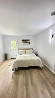 a white bedroom with a large bed and wooden floors at Modern 2BR Stylish & Cozy Unit in Los Angeles