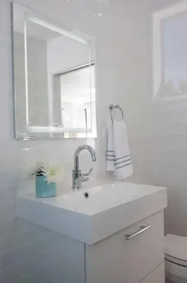 a white bathroom with a sink and a mirror at Elegant Ocean View Studio in Prime Santa Monica Location in Los Angeles
