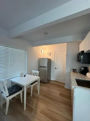 a kitchen with a white table and a refrigerator at Modern Studio Stylish &Cozy Back Unit in Los Angeles