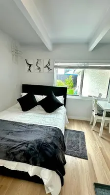 a bedroom with a bed and a desk and a window at Modern Studio Stylish &Cozy Back Unit in Los Angeles