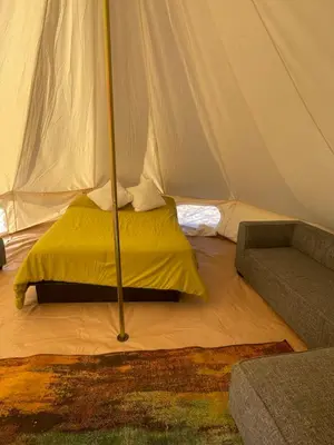 a tent with a bed and a couch in a room at New Yurt City in Lake Los Angeles