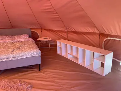 a bedroom with a bed and a table in a tent at New Yurt City in Lake Los Angeles