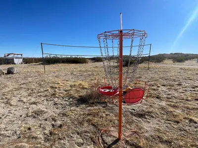 a frisbee golf goal in the middle of a field at New Yurt City in Lake Los Angeles