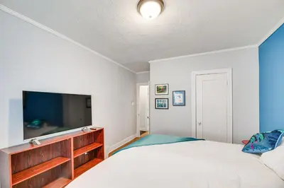 a bedroom with a bed and a flat screen tv at 2 Blocks to Melrose Ave! Home with Furnished Patio in Los Angeles