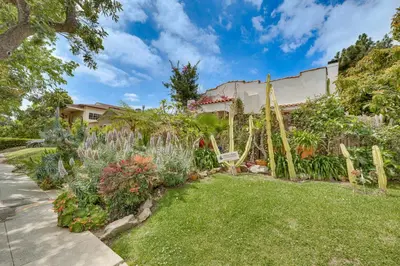 a garden with flowers and plants in front of a house at 2 Blocks to Melrose Ave! Home with Furnished Patio in Los Angeles