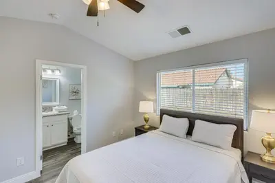 a bedroom with a white bed and a window at Bakersfield Home with Pool Table, Cornhole and More! in Bakersfield