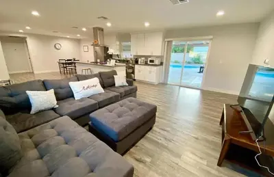 a living room with a large couch and a kitchen at Cheers Hostel in Los Angeles