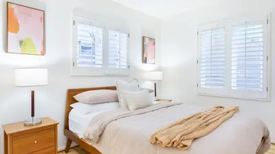 a white bedroom with a bed and two windows at A-Lister by AvantStay Hollywood Hills Luxe Group Escape w Pool in Los Angeles