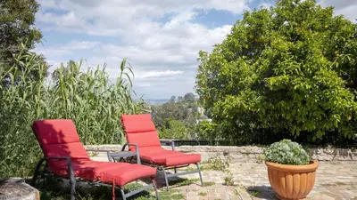 two red chairs sitting on a stone patio at A-Lister by AvantStay Hollywood Hills Luxe Group Escape w Pool in Los Angeles