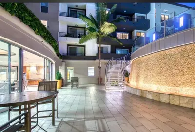 a lobby of a building with a table and a palm tree at Cozy Unit Conveniently Located Pool View in Los Angeles