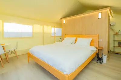 a bedroom with a large bed with a wooden headboard at Urban Oasis Luxe Glamping with King Bed & BBQ in Glendora