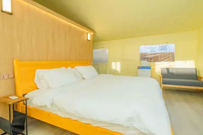 a bedroom with a large white bed and a chair at Urban Oasis Luxe Glamping with King Bed & BBQ in Glendora