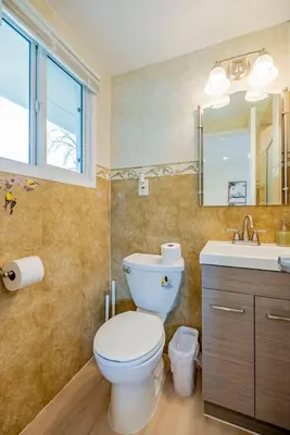 a bathroom with a toilet and a sink and a mirror at Peaceful Family Home with 3 Bedrooms and 2 Bathrooms in Glendora