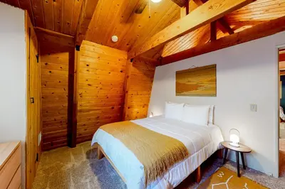 a bedroom with a bed in a room with wooden ceilings at Hidden Wonder in Crestline