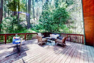 a wooden deck with chairs and a table on it at Hidden Wonder in Crestline