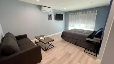 a living room with a bed and a couch at Quintessence ApartHotel in Los Angeles