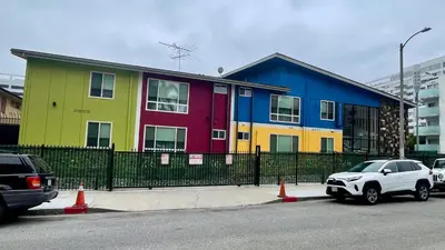 a colorful building with cars parked in front of it at Quintessence ApartHotel in Los Angeles