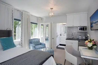 a bedroom with a bed and a kitchen with a desk at Beautiful renovated studio close to ocean! in Los Angeles