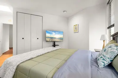 a bedroom with a bed and a tv on the wall at Hollywood Hills Retreat w Sweeping Views 2 Bd 2 Bt in Los Angeles