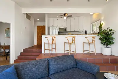a living room with a couch and a kitchen at Hollywood Hills Retreat w Sweeping Views 2 Bd 2 Bt in Los Angeles