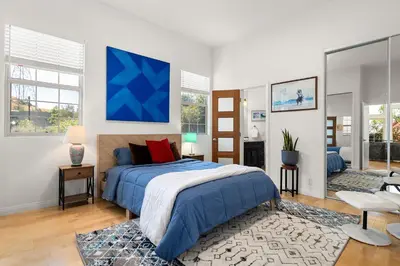 a bedroom with a bed and a blue painting on the wall at Hollywood Hills Retreat w Sweeping Views 2 Bd 2 Bt in Los Angeles
