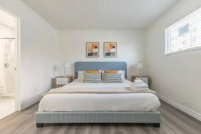 a bedroom with a large bed with a blue headboard at Enjoy Alhambra Night Life at 2BR Apt in Alhambra