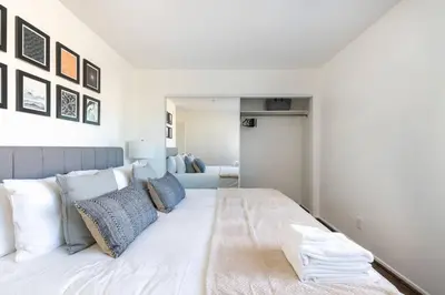 a bedroom with a large white bed with blue pillows at 4 bedroom Alhambra Condo near downtown LA in Alhambra