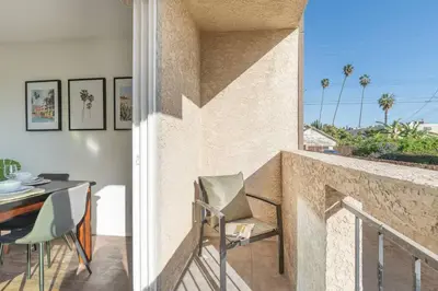 a room with a balcony with a table and chairs at 4 bedroom Alhambra Condo near downtown LA in Alhambra
