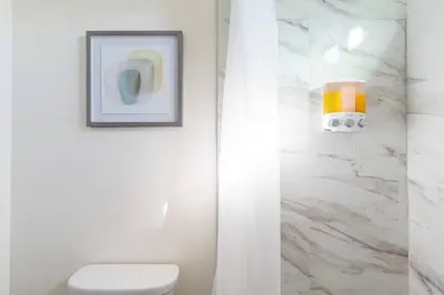 a bathroom with a toilet and a picture on the wall at 4 bedroom Alhambra Condo near downtown LA in Alhambra