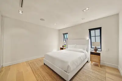 a white bedroom with a white bed and a window at Bella Villa in Los Angeles