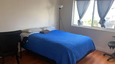 a bedroom with a blue bed and a window at Westminster Zen Home in Westminster