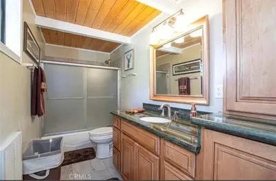 a bathroom with a sink and a toilet and a mirror at Bernina Dr. Retreat in Pine Mountain Club
