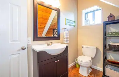 a bathroom with a sink and a toilet and a mirror at Bernina Dr. Retreat in Pine Mountain Club