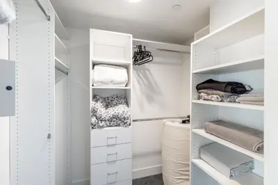 a white walk in closet with white shelves at Hollywood Furnished Apartments in Los Angeles