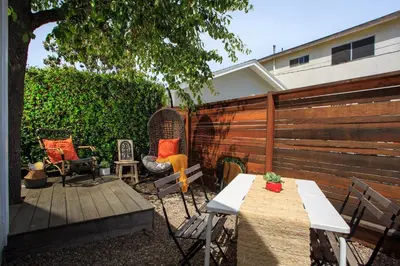 a backyard with a fence and a table and chairs at Stylish 2bed 2bath Culver Cottage with bicycles in Los Angeles