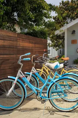 a group of blue bikes parked next to a fence at Stylish 2bed 2bath Culver Cottage with bicycles in Los Angeles