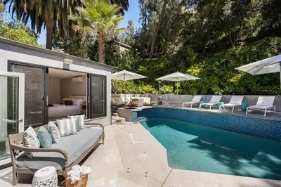 a swimming pool with a couch and chairs next to a house at Beverly Hills Canyon Villa by Stay Awhile Villas in Los Angeles
