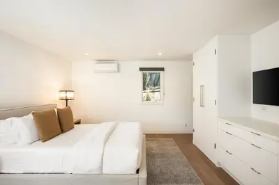 a white bedroom with a bed and a television at Beverly Hills Canyon Villa by Stay Awhile Villas in Los Angeles