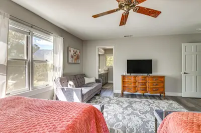 a bedroom with a ceiling fan and a couch and a television at Beautiful Kernville Home with Game Room and Mtn Views! in Kernville