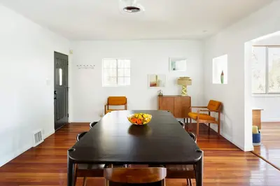 a dining room with a black table and chairs at Silver Lake Mid-century Nestled in the Treetops in Los Angeles