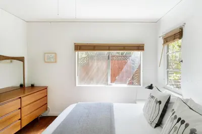 a bedroom with a bed and a dresser and a window at Silver Lake Mid-century Nestled in the Treetops in Los Angeles