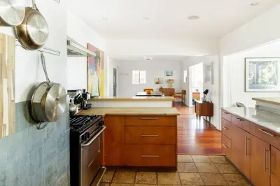 a kitchen with white walls and wooden cabinets at Silver Lake Mid-century Nestled in the Treetops in Los Angeles