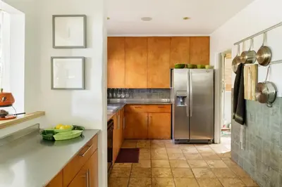 a kitchen with wooden cabinets and a stainless steel refrigerator at Silver Lake Mid-century Nestled in the Treetops in Los Angeles