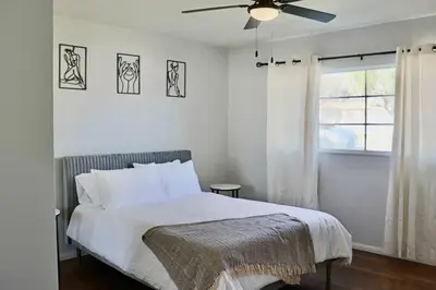 a bedroom with a bed with a ceiling fan at Modern La Cresta in Bakersfield