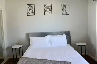 a bedroom with a bed with three pictures on the wall at Modern La Cresta in Bakersfield