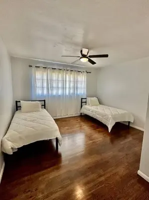 a bedroom with two beds and a ceiling fan at Modern La Cresta in Bakersfield
